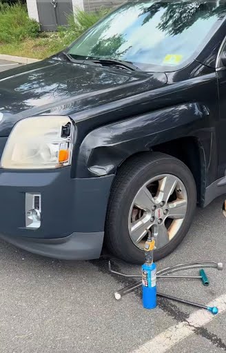Black SUV fender dent repair in progress